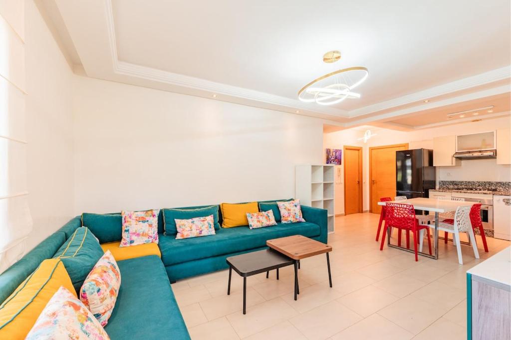 a living room with a blue couch and a table at Ola Blanca - Pool - Garden in Dar Hamida