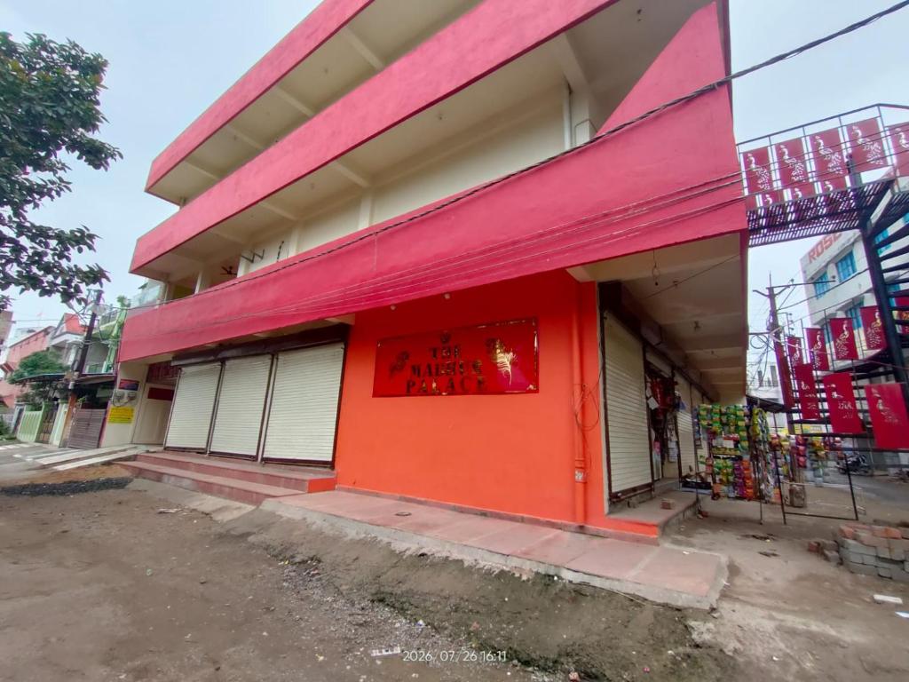 an orange and pink building with a sign on it at Hotel Madhur Palace in Bhopal