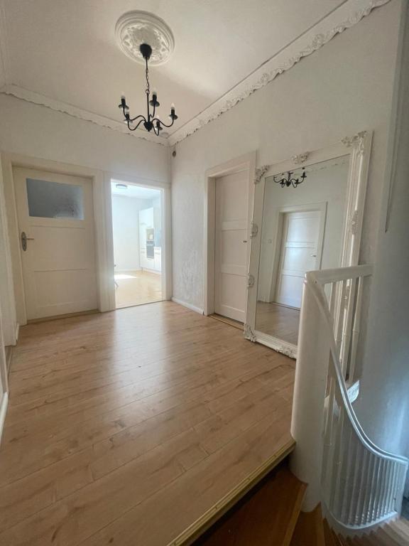 an empty room with a wooden floor and a staircase at Historic Charm Apartment Bayreuth in Bayreuth