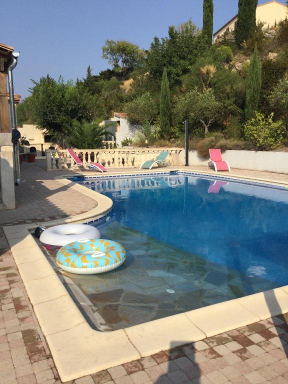 a swimming pool with two inflatables in the water at Les Menendos in Saint-Jean-de-Barrou