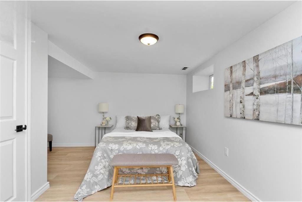 a white bedroom with a bed and a chair at Bright 2 Bedroom Suite in Windsor