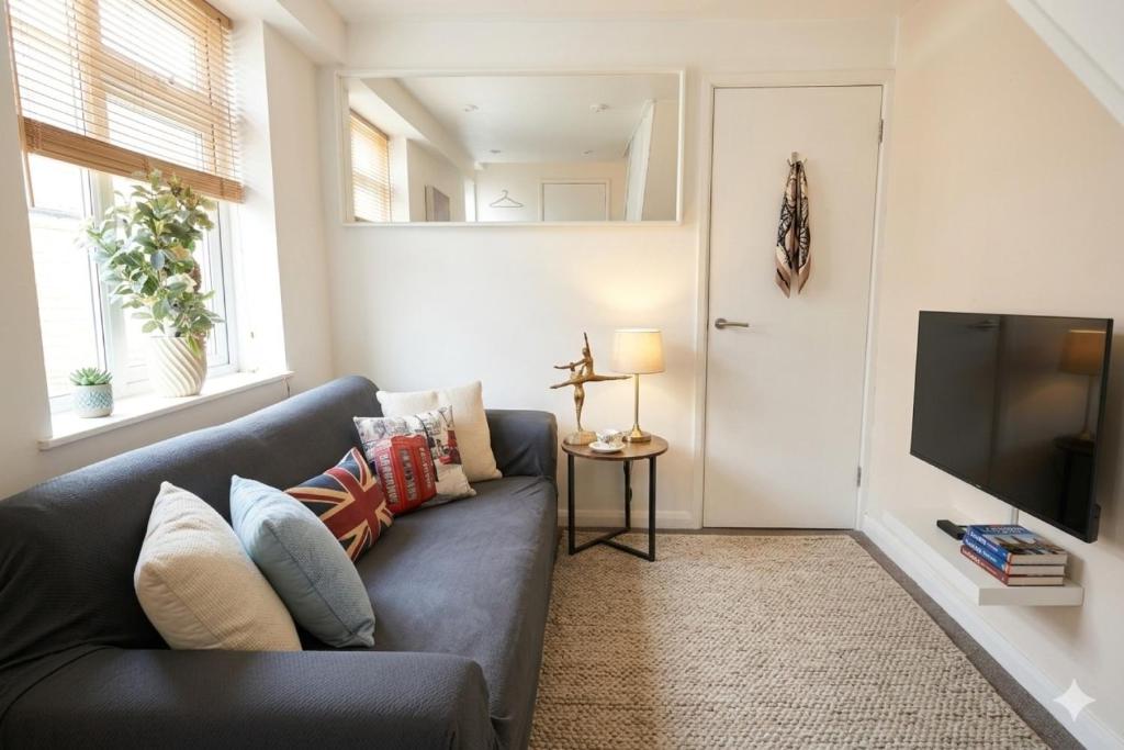 a living room with a couch and a tv at Cosy 3BR House, 2 Bath, Near Luton Centre in Luton