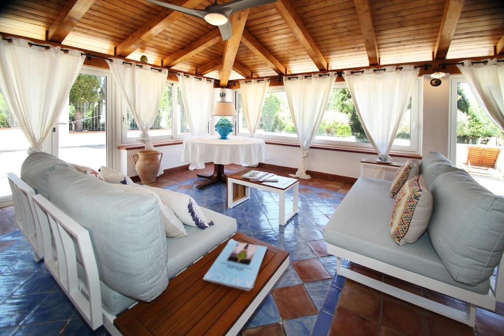 a living room with two couches and a table at Villa Silvia direttamente sul mare in Caronia Marina