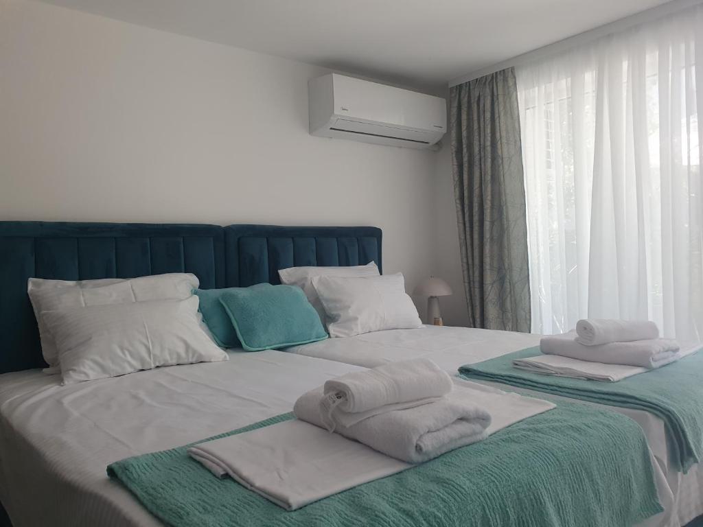 a bedroom with two beds with towels on them at Apartmani Zoka in Niš