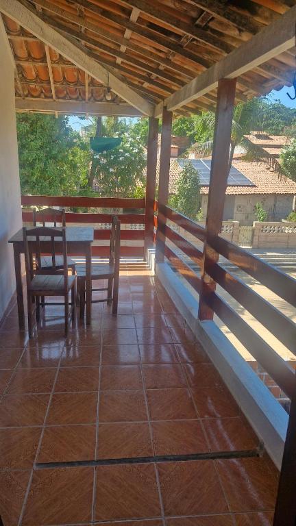 a porch of a house with a table and chairs at Apartamento in Jericoacoara