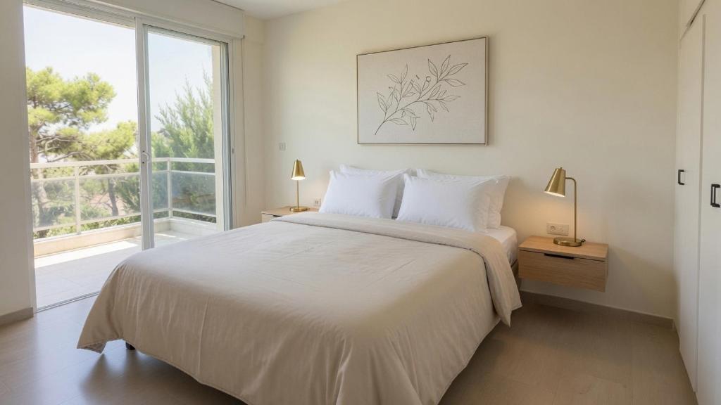 a white bedroom with a large bed and a window at Kineta Prime Suites No2 in Kineta