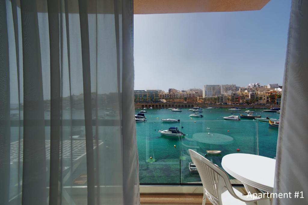 una habitación con vistas a un puerto con barcos en el agua en Marbella Holiday Apartments - Seafront - Wifi, en Marsaskala
