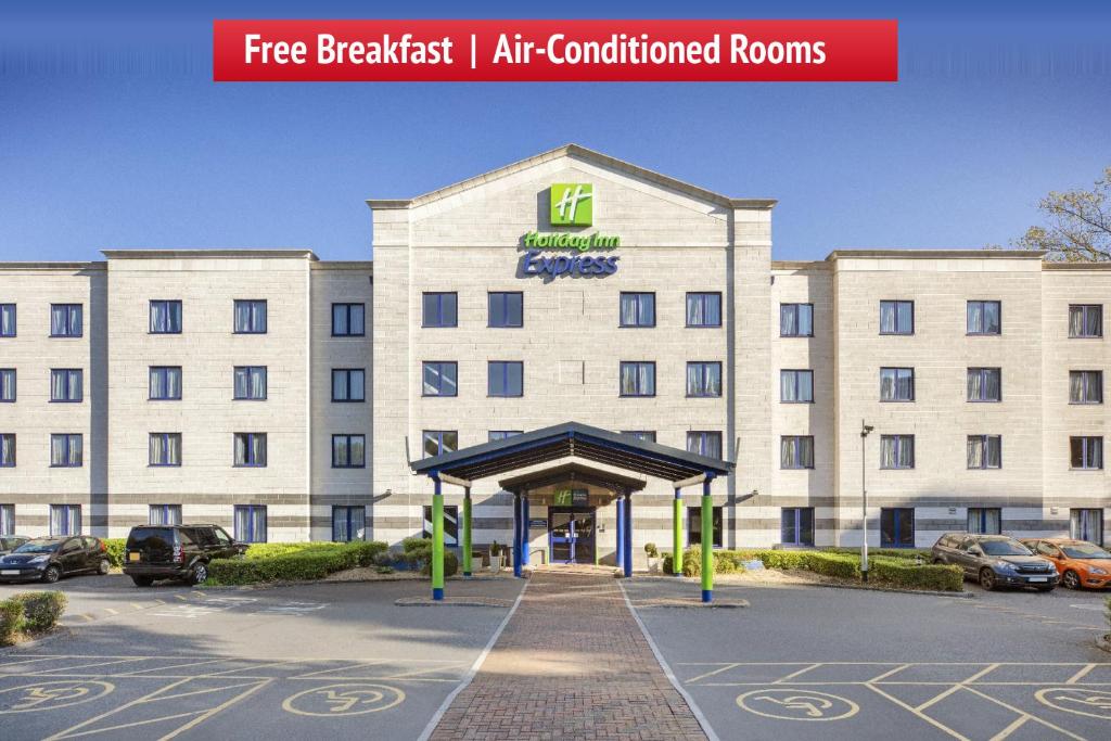 ein großes weißes Gebäude mit einem Parkplatz in der Unterkunft Holiday Inn Express Poole by IHG in Poole