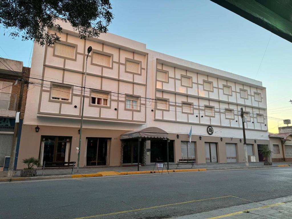 a large pink building on the corner of a street at Hotel 7 De Septiembre in San Clemente del Tuyú