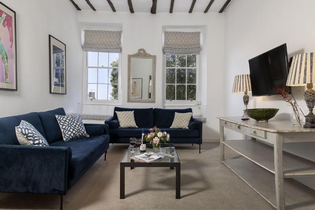 a living room with blue couches and a table at The Haven in Chipping Norton