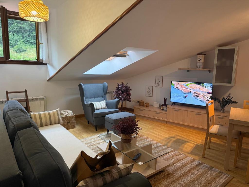 a living room with a couch and a flat screen tv at La escapada in Felechosa