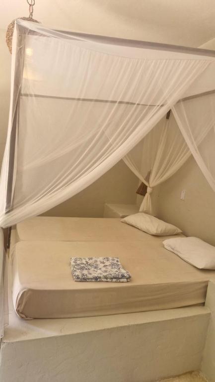 a bedroom with two bunk beds with a canopy at Suíte privada in Jericoacoara