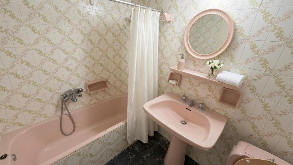 a bathroom with a sink and a tub and a mirror at Kineta Prime Suites No3 in Kineta