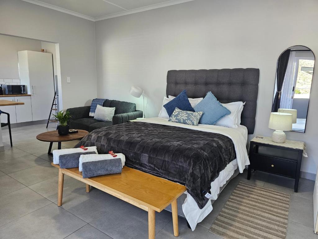 a bedroom with a large bed and a couch at Rosa's Self-catering Unit 2 in Springbok