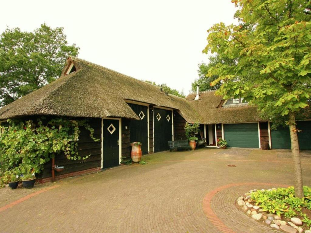 a house with a thatched roof and a driveway at Hytte in Balkbrug