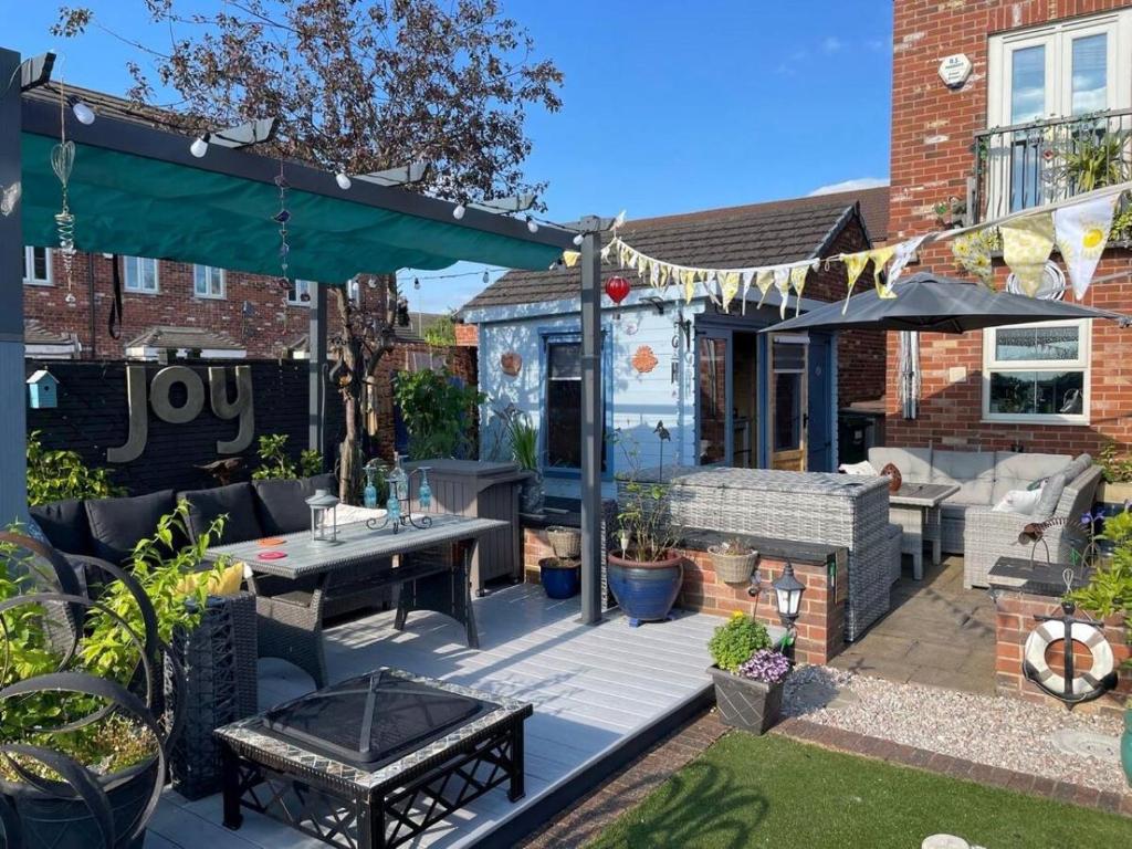 a backyard with a deck with a table and chairs at The Purrfect Creative Retreat in Gainsborough