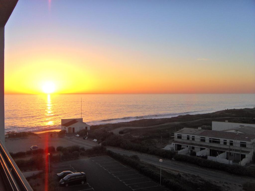 ein Gebäude mit Blick auf den Sonnenuntergang über dem Meer in der Unterkunft Vendée Vue Mer in Saint-Hilaire-de-Riez