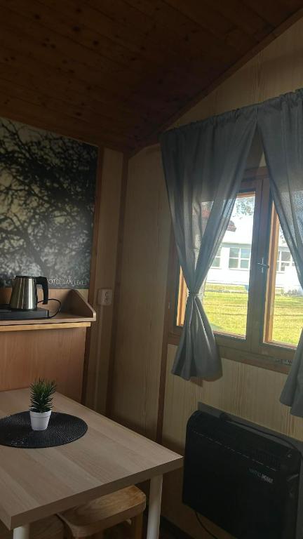 a dining room with a table and a window at Útulné dřevěné chatky Kunovice in Kunowitz