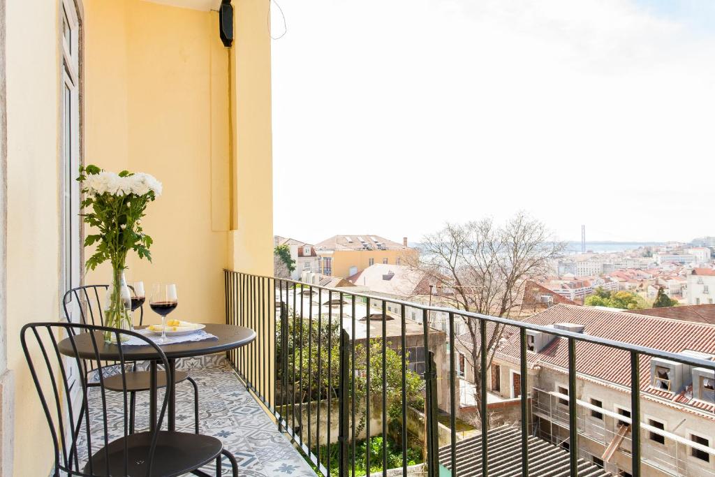 a balcony with a table and chairs and a view at Bairro Alto Viewpoint Flat in Lisbon