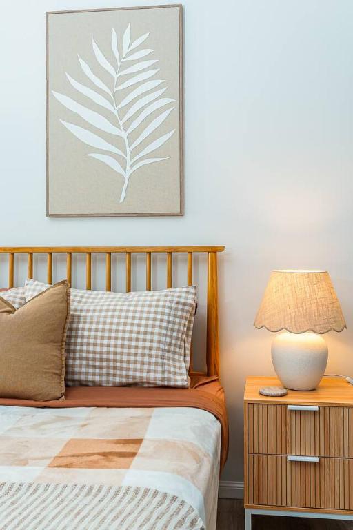 a bedroom with a bed and a table with a lamp at Margate Beach Studio 4 in Redcliffe