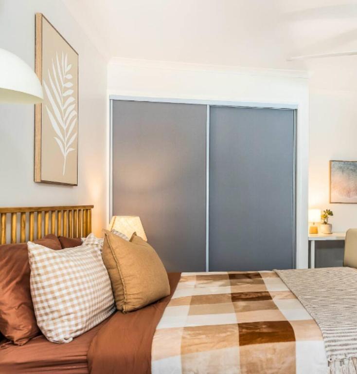 a bedroom with a bed with a large sliding glass door at Margate Beach studio 2 in Redcliffe
