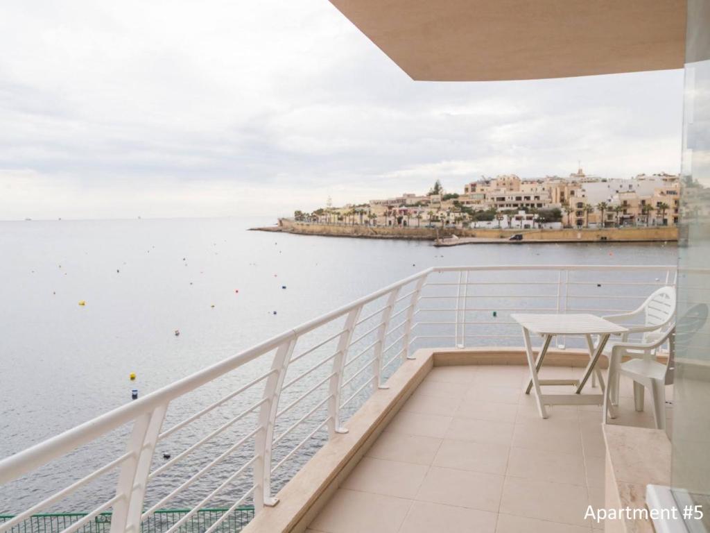 a balcony with a table and a view of the water at Riviera Holiday Apartments - Seafront - Wifi in Marsaskala