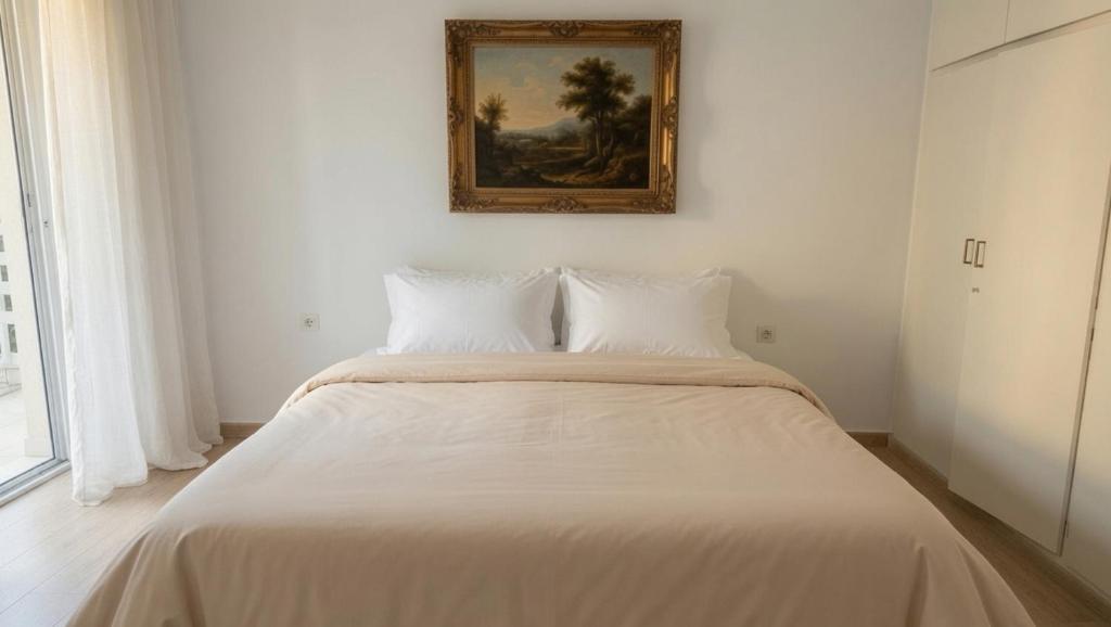 a bed in a room with a picture on the wall at Kineta Prime Suites No5 in Kineta