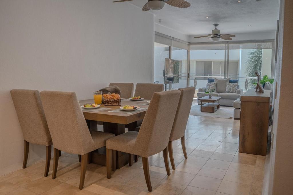 a dining table and chairs in a living room at NITTA 209 Elegant Apartment - Partial Sea Views in Nuevo Nayarit