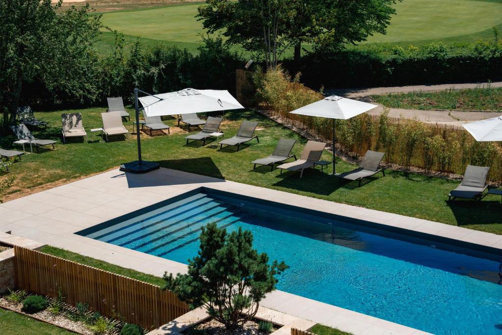 a swimming pool with umbrellas and lounge chairs at Best Western Plus Metz Technopole in Metz