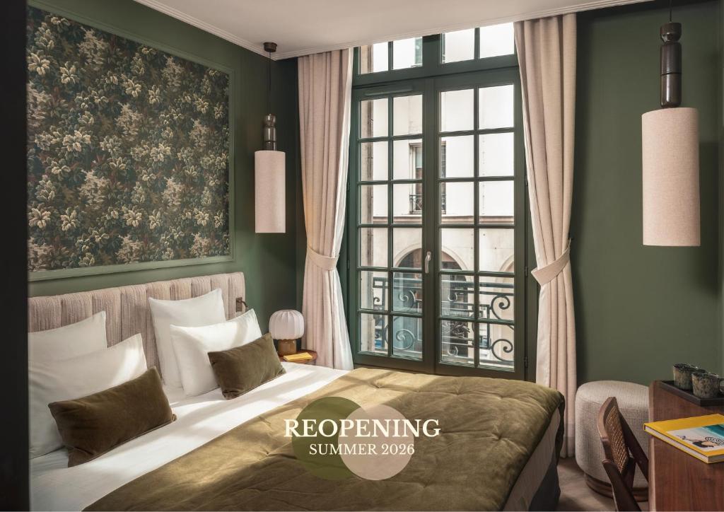 a bedroom with a bed and a large window at Lazare Nomade in Paris