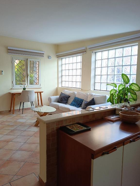 a living room with a couch and some windows at Casa Mille Lire in Ciampino