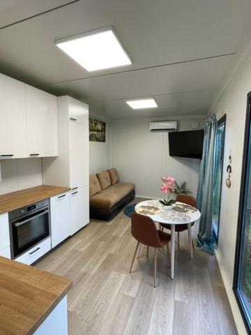 a living room with a kitchen and a table in a room at Bedugnės Namelis in Vilnius