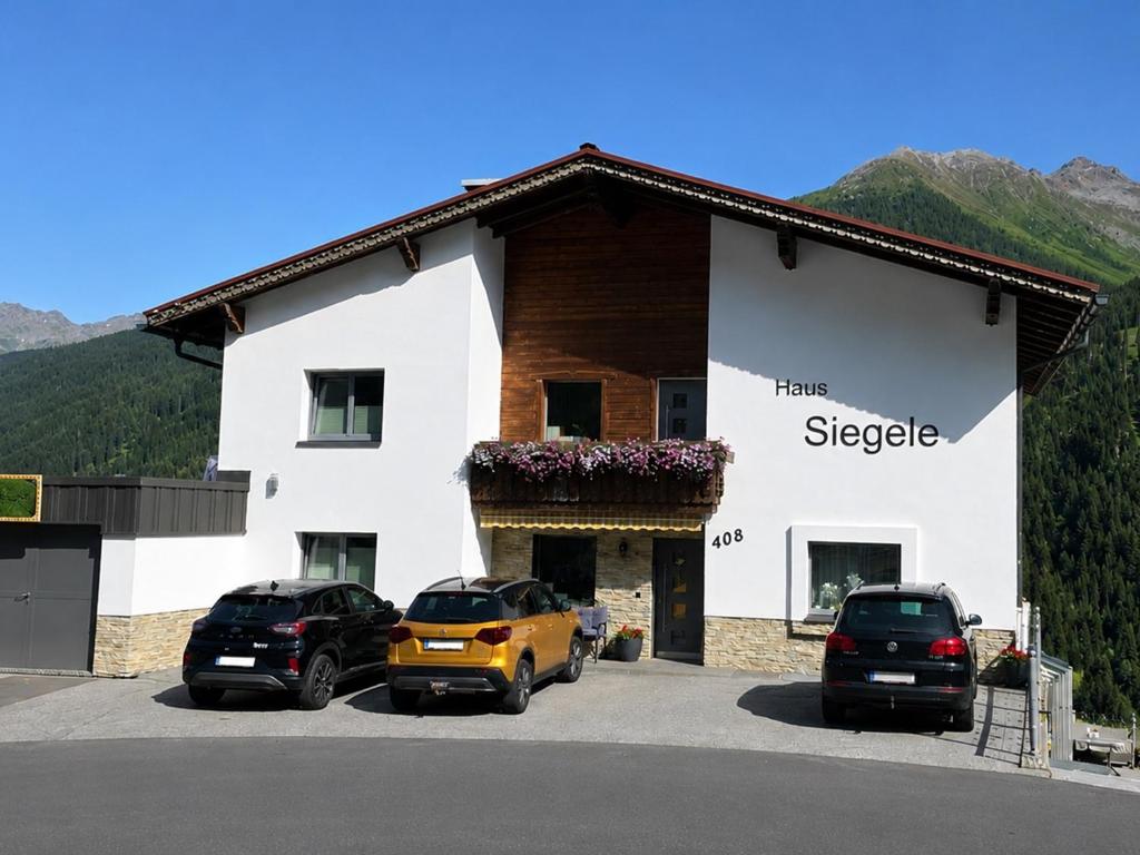 a large white building with cars parked in a parking lot at Siegele - Top 1 in Kappl