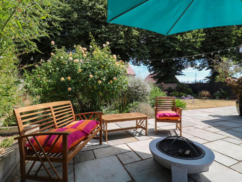 a patio with two chairs and a fire pit at The Annexe Shotley Cottage in Ipswich