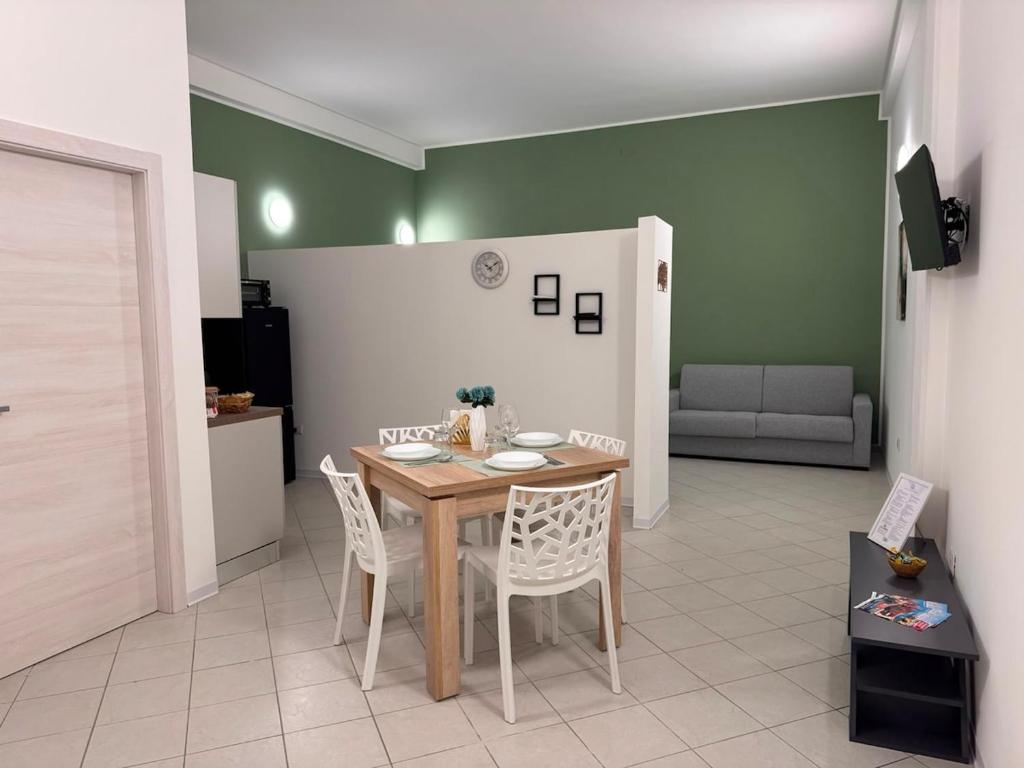 a dining room with a table and chairs and a couch at Scirocco - ideale per coppie e famiglie in Carmiano