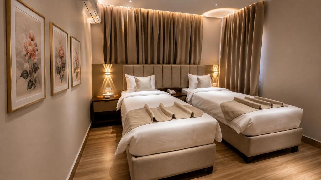 a hotel room with two beds and a chair at Sama Al Sweifieh - سما الصويفية in Amman