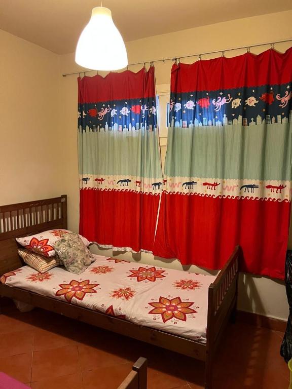 a bedroom with a bed in front of curtains at Cozy chalet in El Alamein