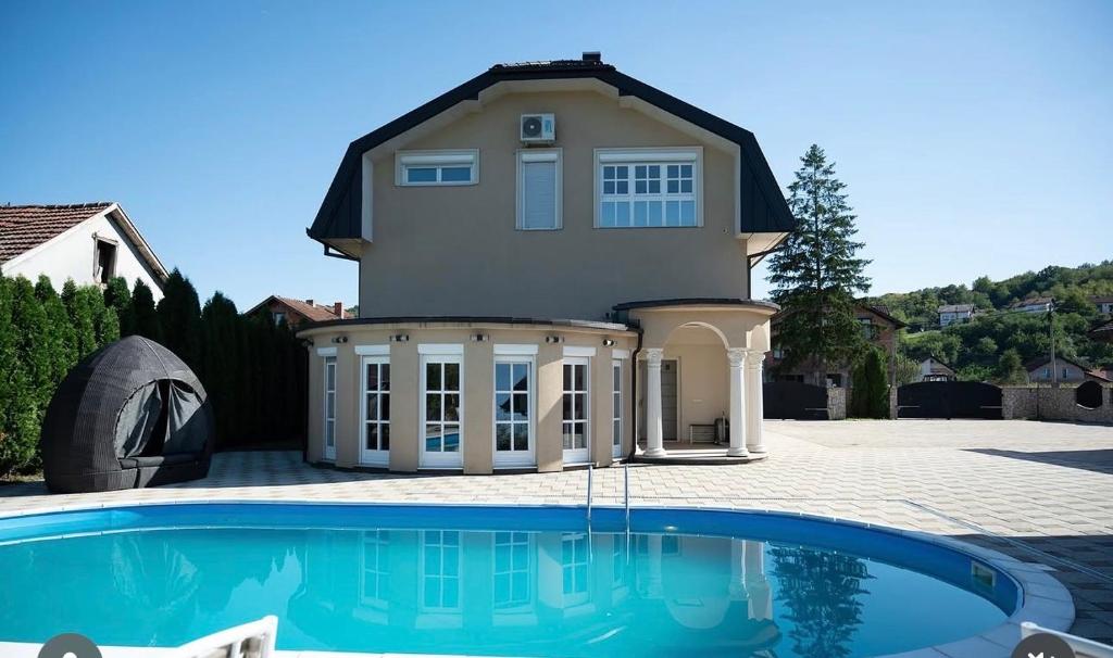 a house with a swimming pool in front of it at Jezero Rudanka in Doboj