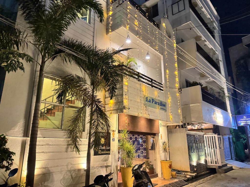 a building with a palm tree in front of it at La Paradise Residency - TIE in Pondicherry