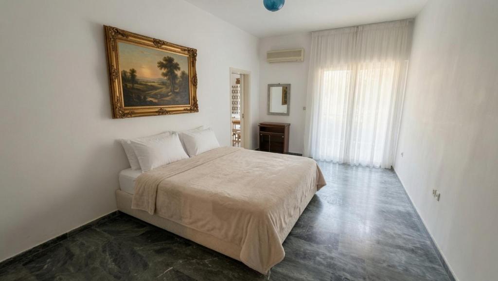 a bedroom with a bed and a painting on the wall at Kineta Prime Suites No6 in Kineta