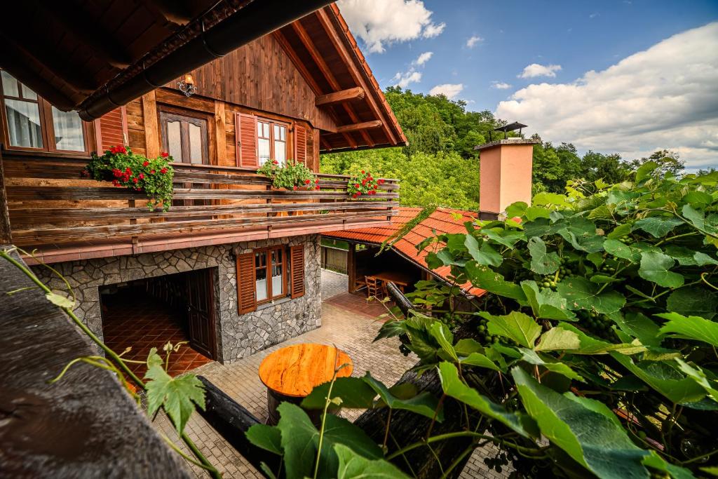a wooden house with a porch and a fireplace at Holiday Home Marta with 4 Bedrooms in Raka