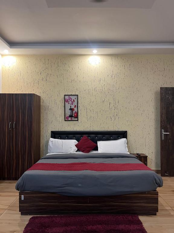 a bedroom with a large bed with a red blanket at Moonshiva stay and cafe in Rishīkesh