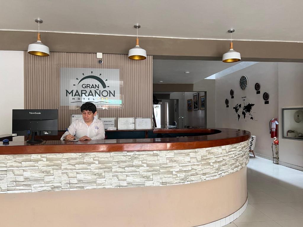 a man standing behind a bar in a restaurant at Gran Marañon Hotel in Iquitos