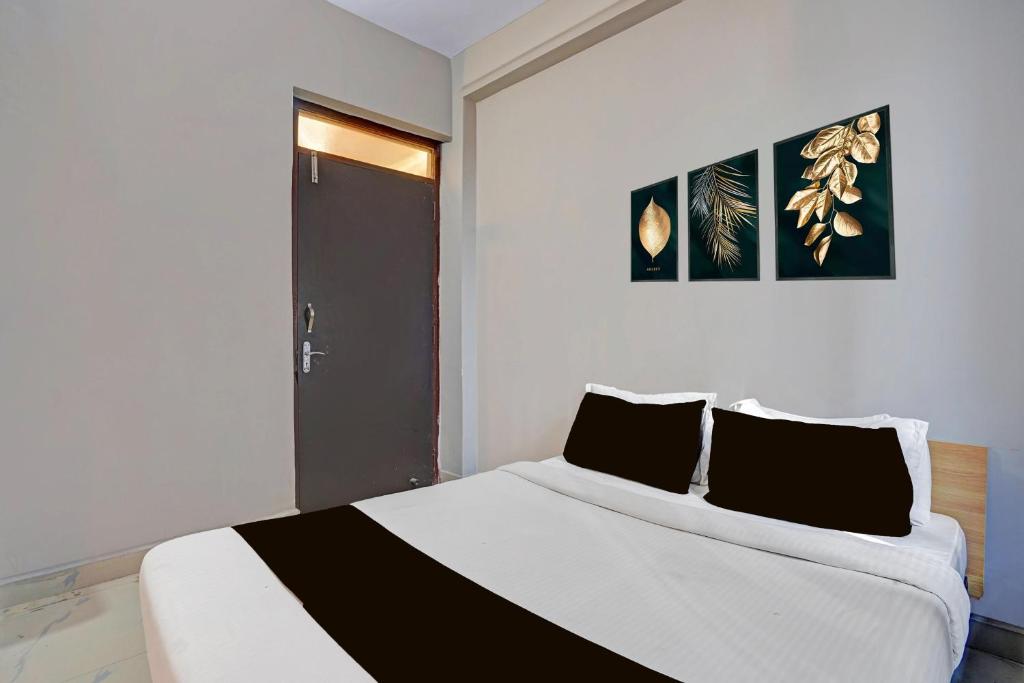 a bedroom with a bed with two black pillows at Super Hotel O AG Colony Park Patna Formerly Capital Pearl in Patna