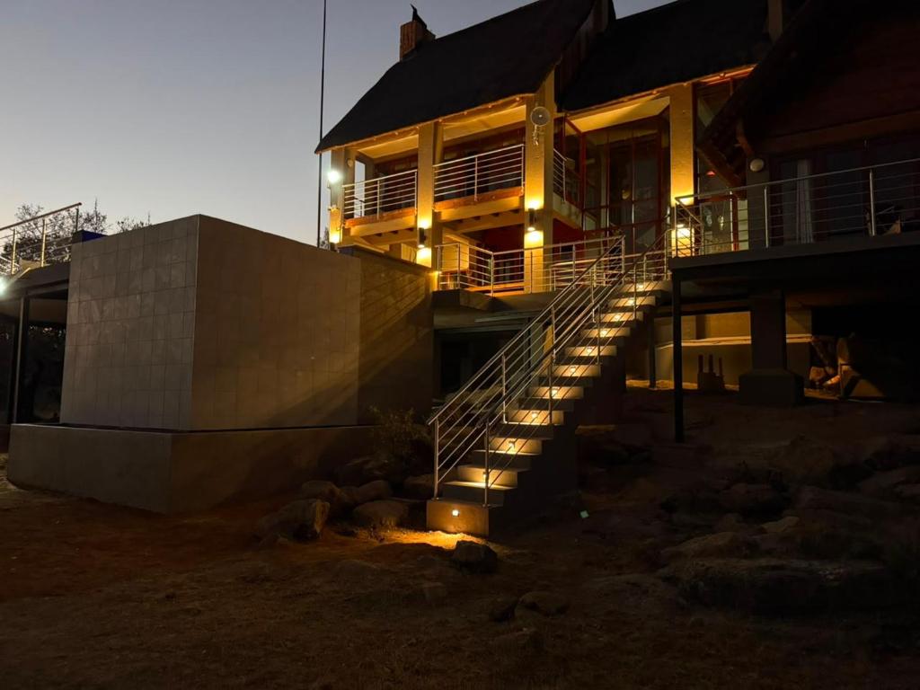 a house with stairs leading up to it at night at Ngong Hill, Mabalingwe in Warmbaths