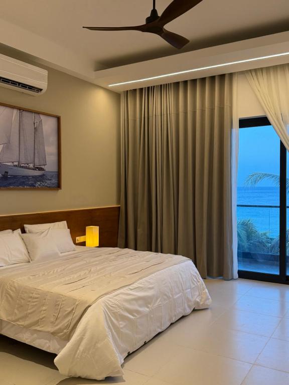 a bedroom with a large bed and a large window at Oceana Trinco in Trincomalee