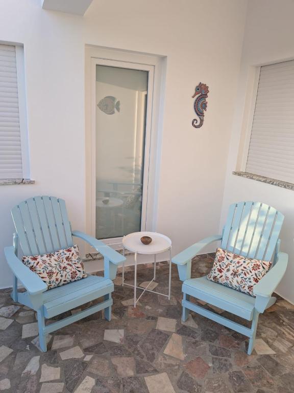 two blue chairs and a table in a room at Casa Crisel in Aljezur