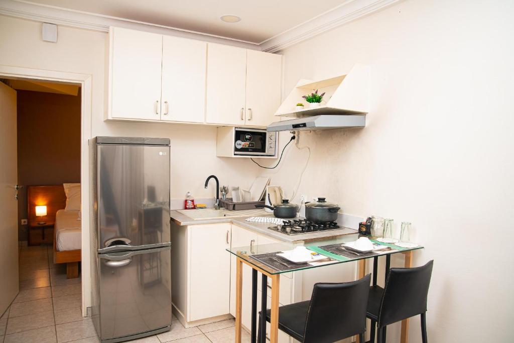 a kitchen with white cabinets and a stainless steel refrigerator at Direl Lodge in Libreville