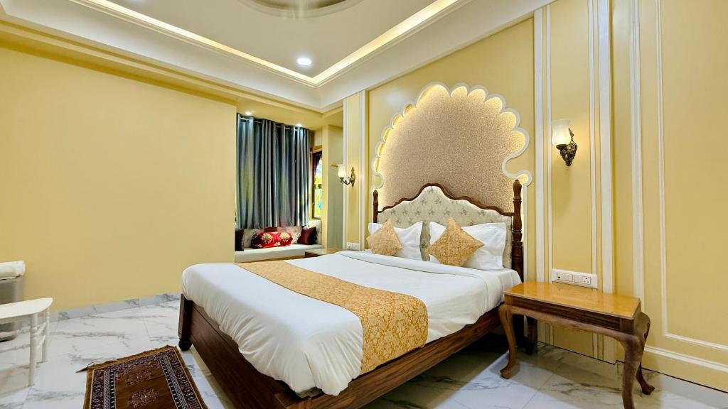 a bedroom with a large bed and a table at Hotel Shree Banke Bihari Heritage in Maheshwar