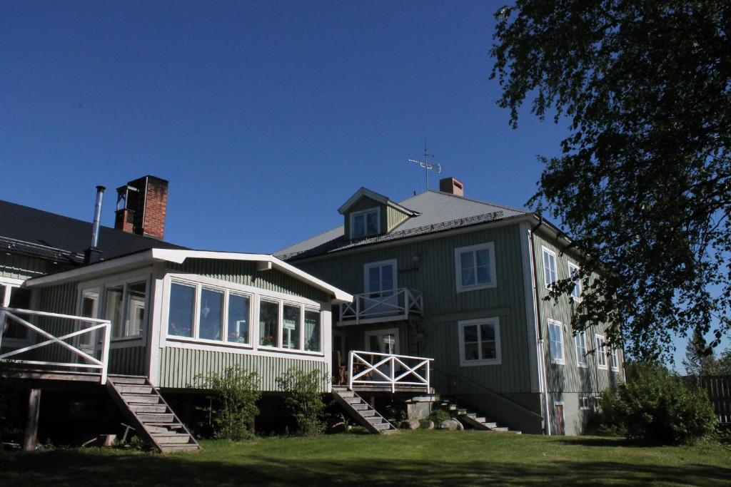 a large green house with stairs leading up to it at Järjagården Hostel in Storsele